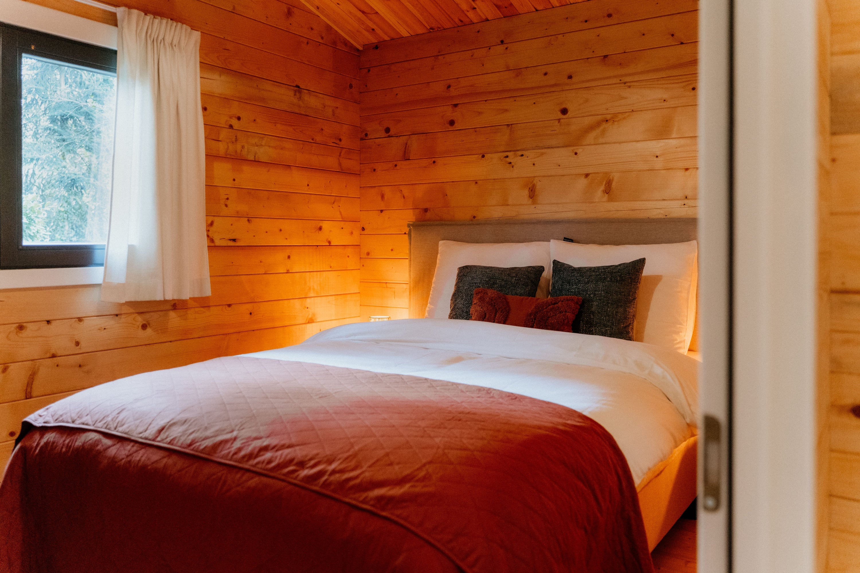 Tweepersoonsbed in houten slaapkamer